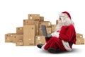 Technological Santa Claus sitting with laptop buys Christmas gifts with e-commerce