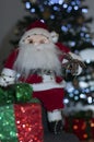 Santa claus sitting next to christmas tree and your gift box Royalty Free Stock Photo