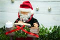 Santa Claus is sitting and playing the piano. On a white wooden fnon. Christmas nativity scene Royalty Free Stock Photo