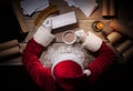 Santa Claus sitting at the table in his room and reading Christmas letter from child Royalty Free Stock Photo