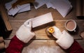 Santa Claus sitting at the table in his room and reading Christmas letter from child Royalty Free Stock Photo