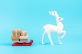 Santa claus sleigh with gift boxes and white reindeer on blue background. Minimal New Year concept Royalty Free Stock Photo