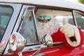 Santa Claus Smiles as he drives his Hot Rod Car on Christmas Eve