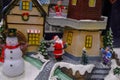 santa claus in the snow across cute colorful houses and snow man. Christmas scene. Christma decoration. Postcard Royalty Free Stock Photo