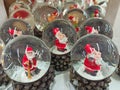 Santa Claus in snow globe closeup on shop shelf. Decorative toys in New Year eve