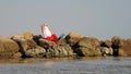 Santa Claus sunbathes. Santa Claus having fun. Funny Santa, in sunglasses and flippers sitting on rocky beach by the sea Royalty Free Stock Photo