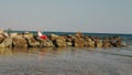 Santa Claus sunbathes. Santa Claus having fun. Funny Santa, in sunglasses and flippers sitting on rocky beach by the sea Royalty Free Stock Photo