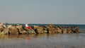 Santa Claus sunbathes. Santa Claus having fun. Funny Santa, in sunglasses and flippers sitting on rocky beach by the sea Royalty Free Stock Photo