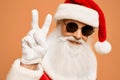 Santa Claus in sunglasses and gloves doing victory sign Royalty Free Stock Photo