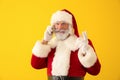 Santa Claus talking by mobile phone on color background Royalty Free Stock Photo