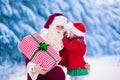 Santa Claus talking to little girl in snowy park Royalty Free Stock Photo