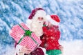 Santa Claus talking to little girl in snowy park Royalty Free Stock Photo