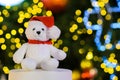 Santa claus teddy bear eyes who wearing hat sitting in front of colorful bokeh light Royalty Free Stock Photo