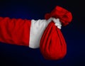 Santa Claus theme: Santa holding a big red sack with gifts on a dark blue background Royalty Free Stock Photo