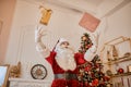 Santa Claus throwing and playing with presents near the fireplace and christmas tree with gifts. New year and Merry Christmas , Royalty Free Stock Photo