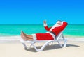 Santa Claus thumbs up gesturing on sunlounger at tropical beach Royalty Free Stock Photo