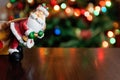 Santa Claus toy brings Christmas tree at blue snowy night bokeh Royalty Free Stock Photo