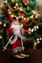 Santa Claus toy brings Christmas tree at blue snowy night bokeh Royalty Free Stock Photo