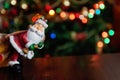 Santa Claus toy brings Christmas tree at blue snowy night bokeh Royalty Free Stock Photo