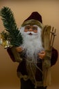 Santa Claus toy holding wooden skis and a fir branch with a bell Royalty Free Stock Photo