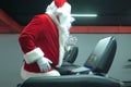 Santa Claus training at the gym on Christmas Day. Santa Claus running in machine treadmill at fitness gym club. Royalty Free Stock Photo