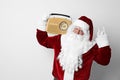 Santa Claus with vintage radio on light background. Christmas music Royalty Free Stock Photo