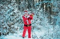 Santa Claus walking to the winter forest with a bag of gifts, snow landscape. Happy New Year. Postcard, greeting card. Royalty Free Stock Photo