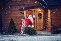 Santa Claus waving on the front porch of his wooden house Royalty Free Stock Photo