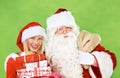 Santa claus, woman and hug for Christmas gift in studio holiday celebration, box giving and festive vacation. Old man Royalty Free Stock Photo