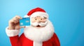 Santa Clause presenting a gift card plain blue backgrouund - stock picture