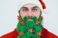Santa Clause in red clothes with green beard smiles