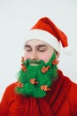 Santa Clause in red clothes with green beard smiles