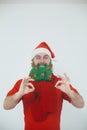 Santa Clause in red clothes with green beard smiles