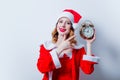 Santa Clous girl in red clothes with alarm clock