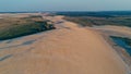 aerial picture of a beautiful blue lagoon next to the desert sand dunes