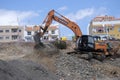 Crawler excavators working on site near residential houses and beach.