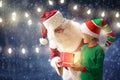 Santa and elf deliver Christmas presents Royalty Free Stock Photo