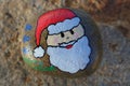 Santa face painted on a small rock