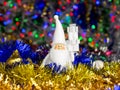 Santa figure with Christmas balls, tinsel on blurred lights background Royalty Free Stock Photo