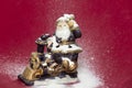 Decorative Santa figurine and snowing on red background 