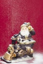 Decorative Santa figurine and snowing on red background 