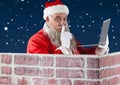 Santa with finger on lip using laptop Royalty Free Stock Photo