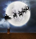 Santa flying over full moon and roof top