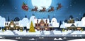 Santa Flying In Sledge With Reindeers In Sky Over Village Houses, Merry Christmas And Happy New Year Banner Winter Royalty Free Stock Photo