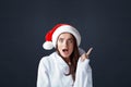 Santa Girl. Beautiful Woman In Christmas Hat Portrait. Excited Model Having Idea And Pointed Up. Royalty Free Stock Photo