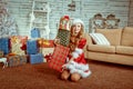 Santa girl holding Christmas gifts. Young happy woman in santa hat holding Christmas present Royalty Free Stock Photo