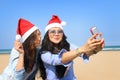 Santa girls take selfie on a sunny beach