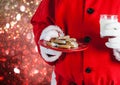 Santa hand holding cookies and a glass of milk Royalty Free Stock Photo