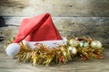Santa Hat with Christmas decorations on old wooden background. Royalty Free Stock Photo