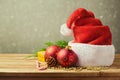 Santa Hat with Christmas decorations on wooden table over blur background Royalty Free Stock Photo